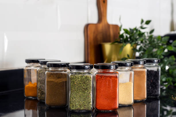 Variety of dried botanical herbs arranged in glass jars with natural wooden background